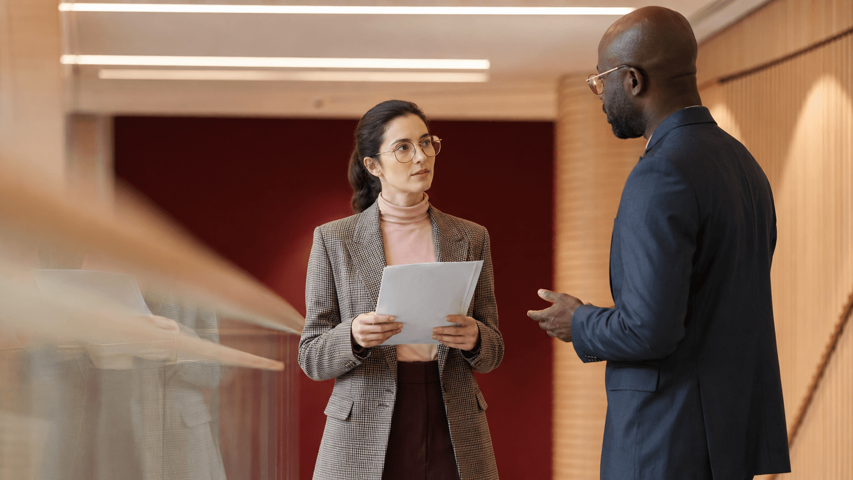 Échange entre une responsable RH et un manager dans un couloir de bureaux
